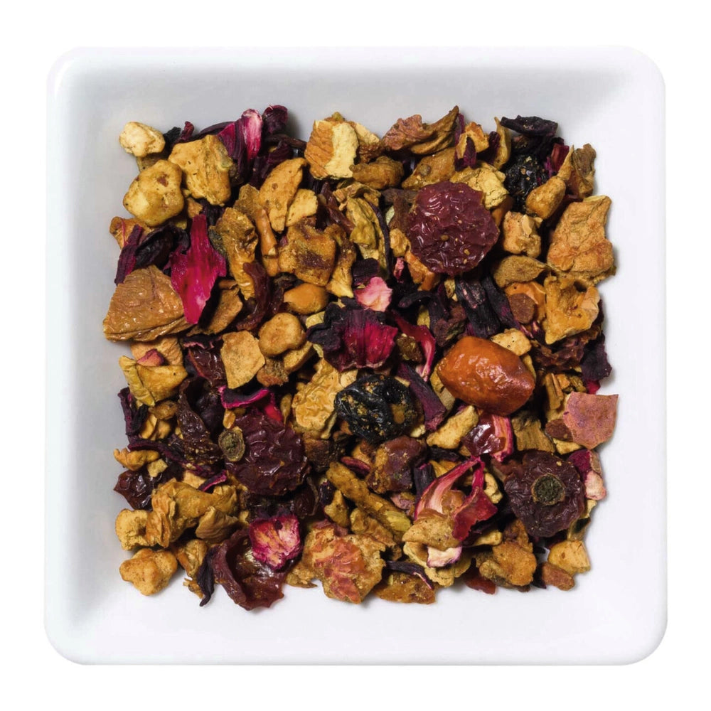 Freigestellte Nahaufnahme der aromatisierten Früchteteemischung "Schlemmerapfel" mit Apfelstücken, Gewürzen und Marzipanstückchen.