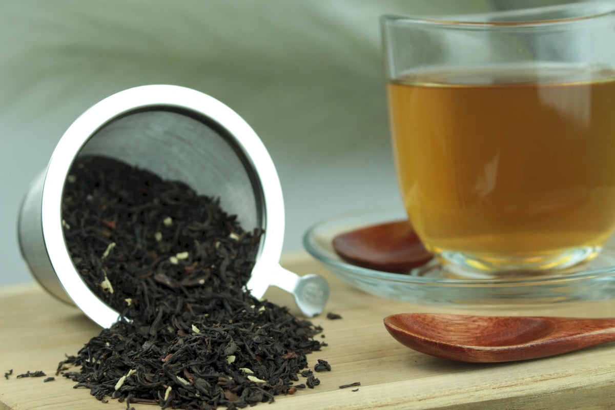 Produktfoto einer Tasse Tee und der Verpackung von Schoko-Sahne-Trüffel, schwarzer Tee mit verführerischer Schokoladencreme-Note.