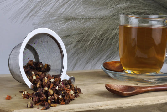 Früchtetee Backbirne in Teetasse, goldgelber Aufguss, loser Früchtetee im Sieb