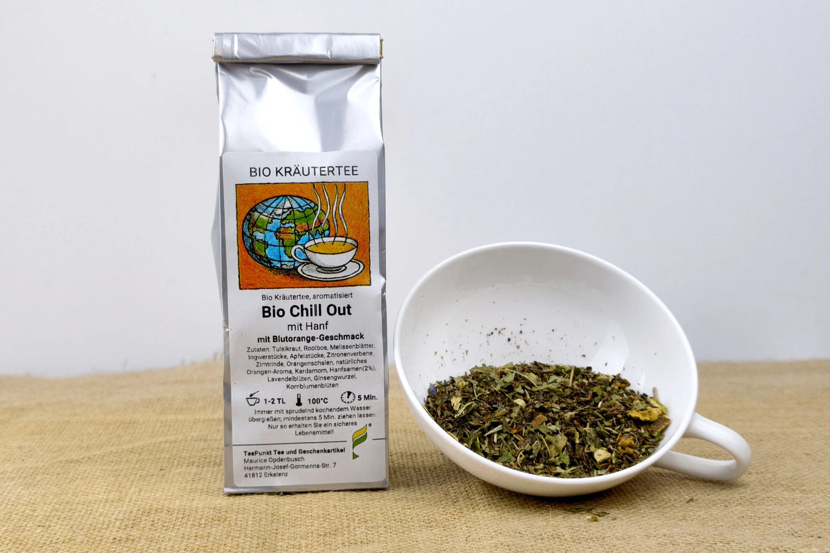 Packung Bio Chill Out Kräutertee neben einer weißen Tasse mit losem Kräutertee