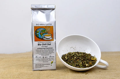Packung Bio Chill Out Kräutertee neben einer weißen Tasse mit losem Kräutertee