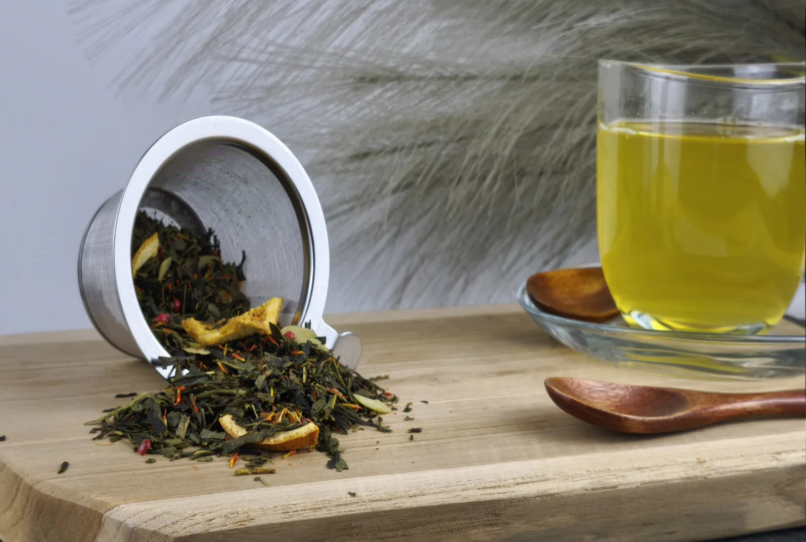 Grüner Tee Sencha in Teetasse, hellgrüner Aufguss, loser Tee im Sieb