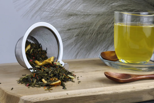 Grüner Tee Sencha in Teetasse, hellgrüner Aufguss, loser Tee im Sieb