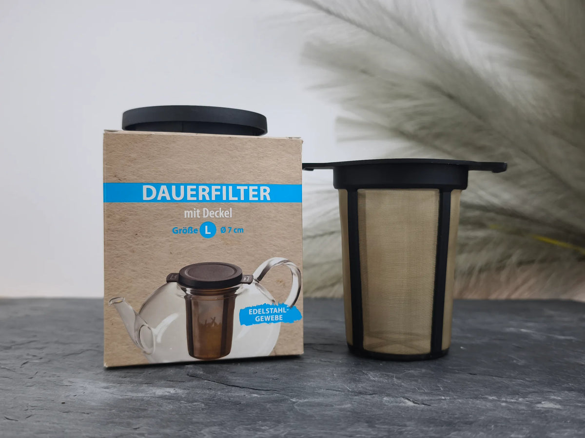Produktfoto der Verpackung und des Dauerfilters mit Deckel in Schwarz, Größe L (Ø 7 cm), aus Kunststoff und Edelstahlgewebe.