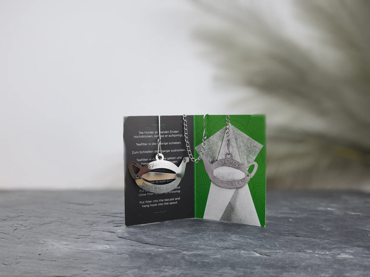 Produktfoto der Verpackung mit dem Edelstahl Tee-Filter Halter und dem Tropfenfänger aus 18/8 Edelstahl, praktisch, stabil und wiederverwendbar.