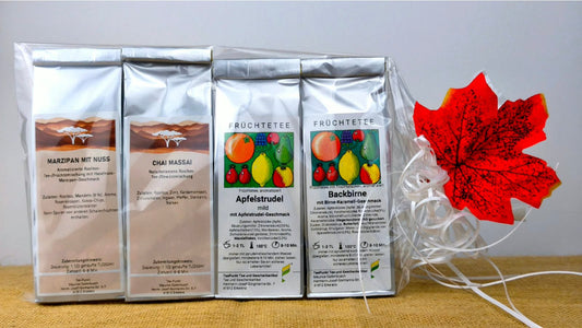 Herbstzauber Tee-Set mit vier silbernen Teepackungen Marzipan mit Nuss, Chai Massai, Apfelstrudel und Backbirne in Geschenkverpackung mit herbstlicher Dekoration.