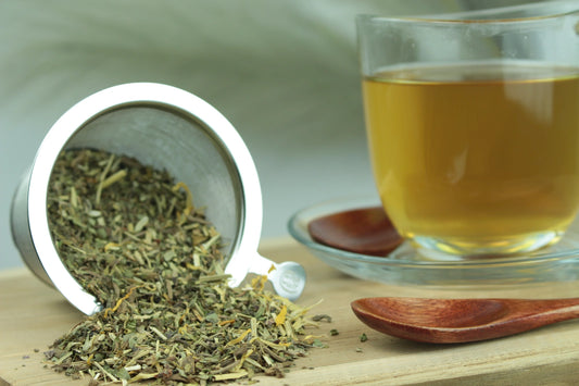 Produktfoto einer Tasse Tee und losen Teeblättern von Schlaf gut, naturbelassener Kräutertee mit Baldrian und Melisse.