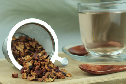 Produktfoto einer Tasse Tee und losen Teeblättern von Schlemmerapfel, aromatisierte Früchteteemischung mit Apfel, Gewürzen und Marzipan.