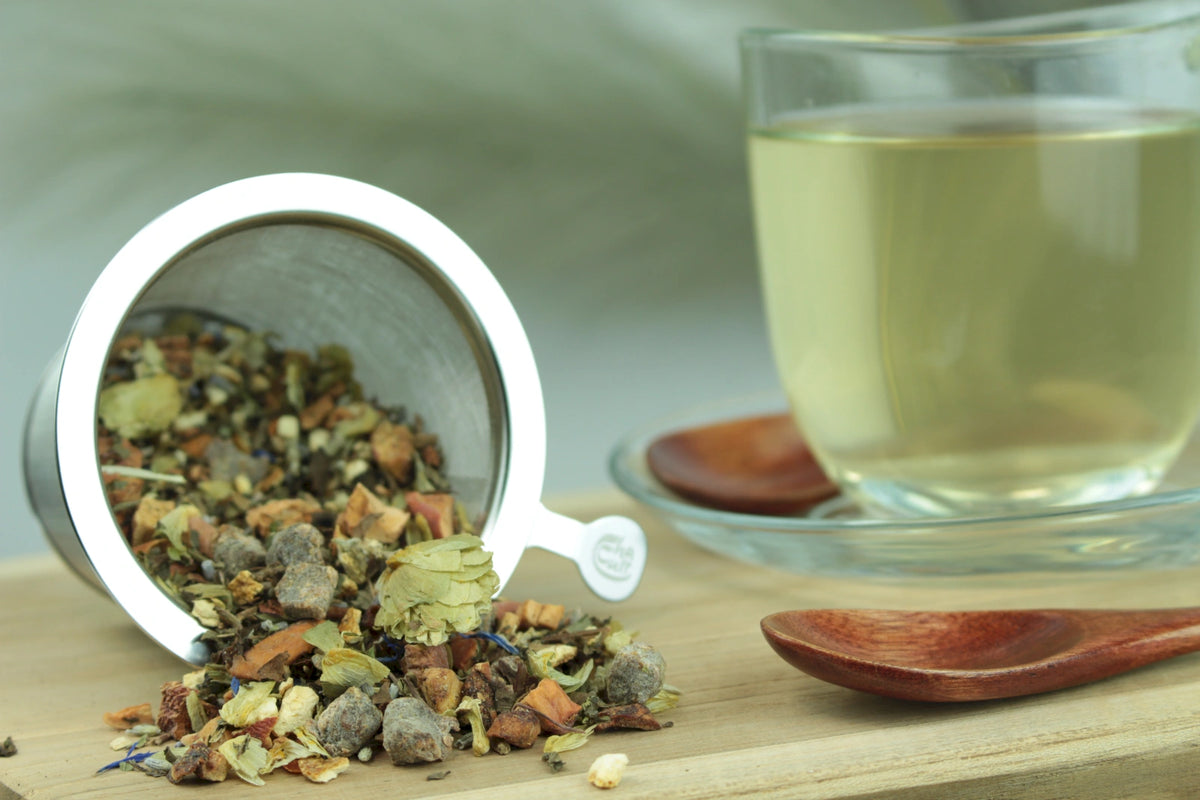 Produktfoto einer Tasse Tee und losen Teeblättern von Silence, aromatisierte Kräuter-Früchteteemischung mit süßem Pfirsich.