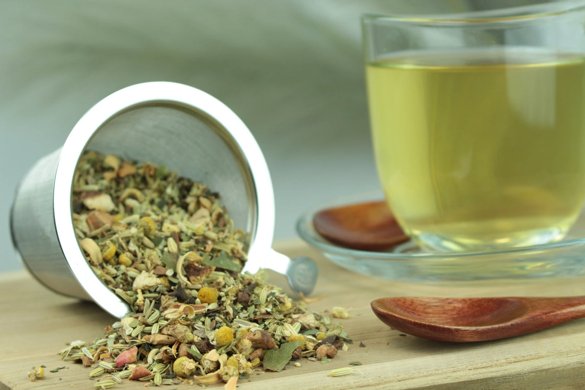Produktfoto einer Tasse Tee und losen Teeblättern von Sorglos, naturbelassene Kräuterteemischung mit Kamille, Fenchel und Gewürzen.