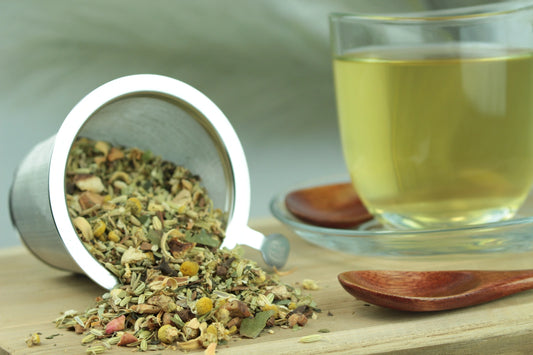 Produktfoto einer Tasse Tee und losen Teeblättern von Sorglos, naturbelassene Kräuterteemischung mit Kamille, Fenchel und Gewürzen.