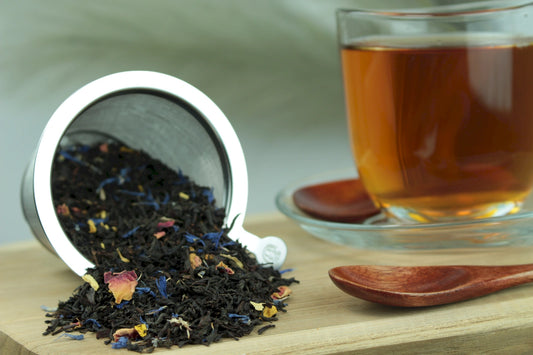 Produktfoto einer Tasse Tee und der Verpackung von Südseezauber, aromatisierter Schwarztee mit Mango, Maracuja und Papaya.