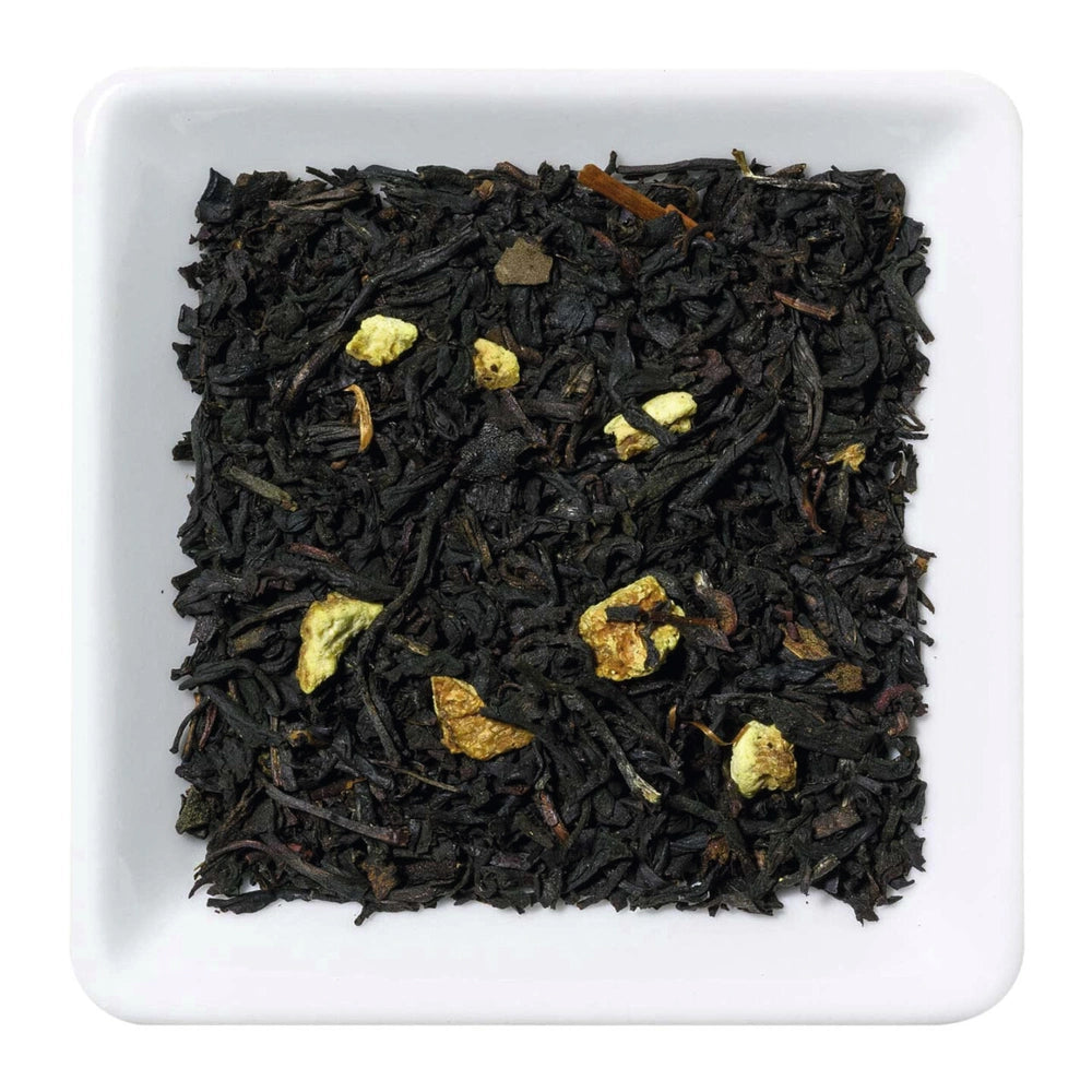 Freigestellte Nahaufnahme des aromatisierten Schwarztees "Sweet Lemon" mit Litschi-Stücken und Zitronenschalen.