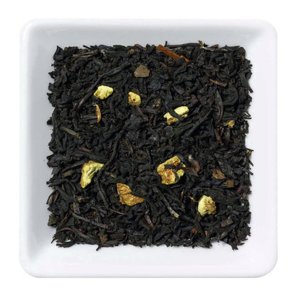Freigestellte Nahaufnahme des aromatisierten Schwarztees "Sweet Lemon" mit Litschi-Stücken und Zitronenschalen.