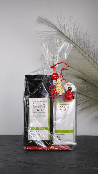 Tee Geschenkset mit Sencha Tannengrün und Sencha Vanille, festliches Doppelpack in Geschenkfolie mit roter Schleife und Holzanhänger.