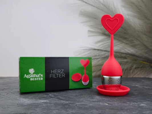 Produktfoto der Verpackung und des herzförmigen Teefilters „Herz“ von Agatha's Bester in Rot für eine stilvolle Teezubereitung mit Liebe.