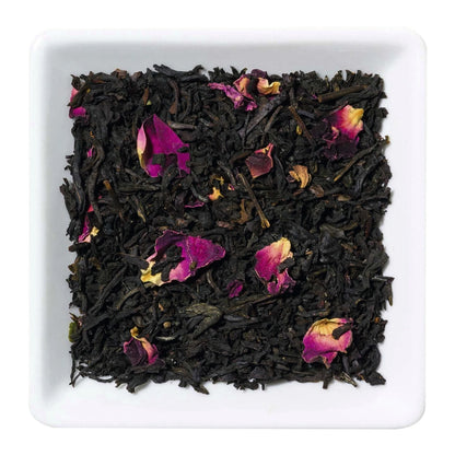 Freigestellte Nahaufnahme des aromatisierten Schwarztees "Tropenfeuer" mit Jackfruit-Stücken und Rosenblütenblättern.