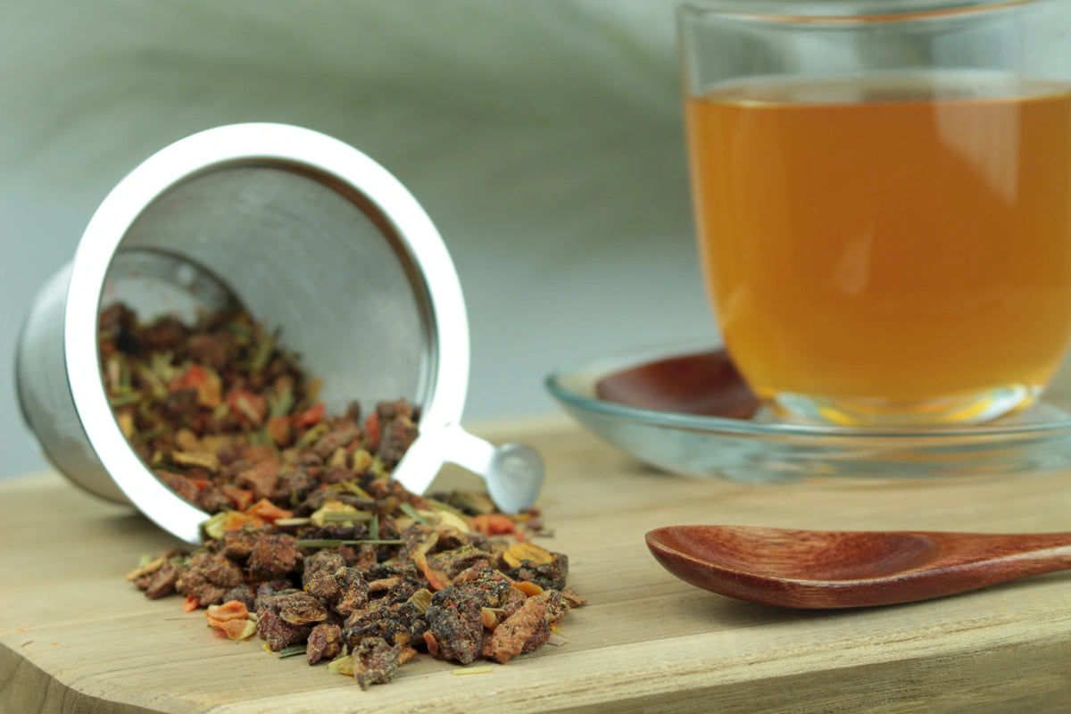 Produktfoto einer Tasse Tee und losen Teeblättern von Vitamin Quelle, aromatisierter Früchtetee mit Multivitaminkomplex und Grapefruitnote.
