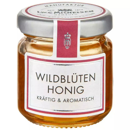 Wildblütenhonig im kleinen Glas von L.W.C. Michelsen mit rosa Etikett kräftig und aromatisch auf weißem Hintergrund