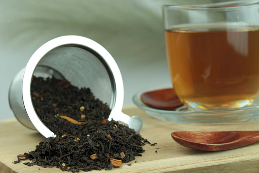 Produktfoto einer Tasse Tee und der Verpackung von Wintertraum, aromatisierter Schwarztee mit Zimt, Vanille und Apfel.