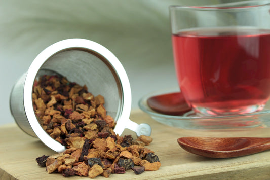 Produktfoto einer Tasse Tee und losen Teeblättern von Zimt-Pflaume, aromatisierte Früchte-/Gewürzteemischung mit Pflaume und Zimt.