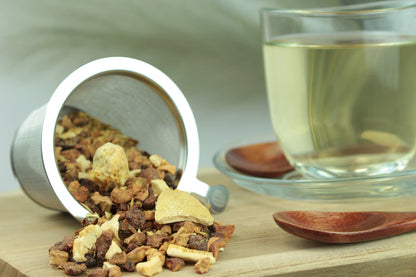 Produktfoto einer Tasse Tee und losen Teeblättern von Zitro-Schock, aromatisierte Früchteteemischung mit spritziger Zitrusnote und Physalis.